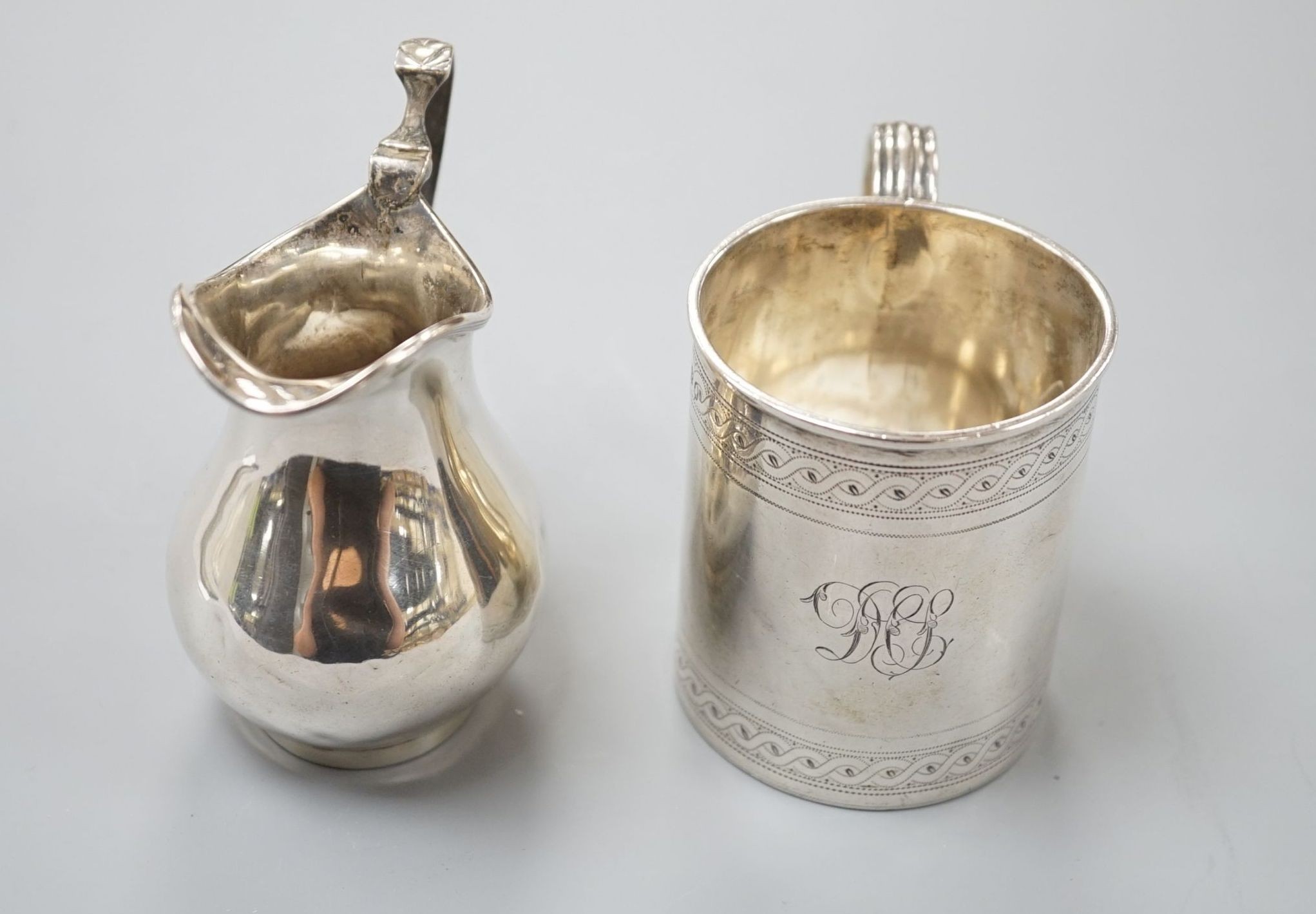 A George III engraved silver christening mug, London, 1810, 67mm and a later silver cream jug, 5oz.